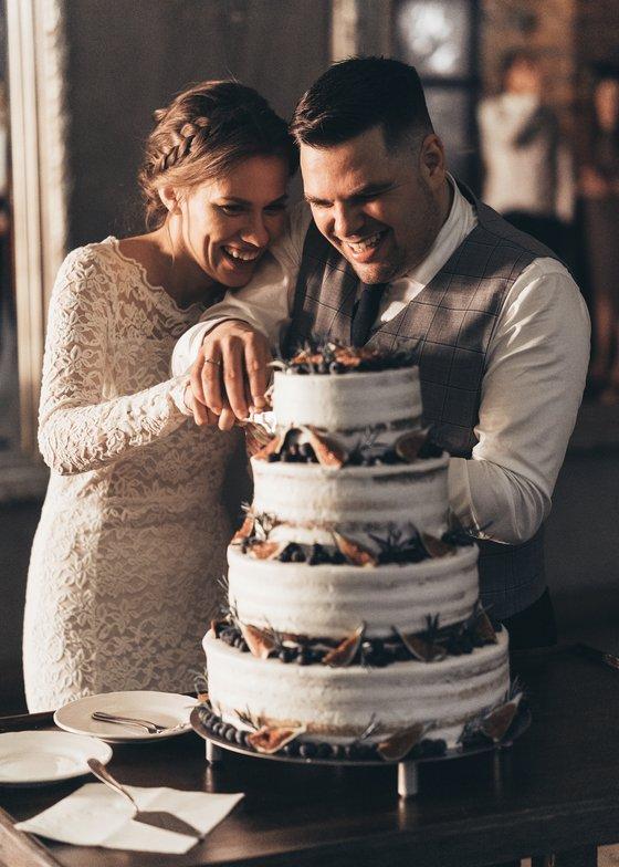 Para młoda krojąca wspólnie tort weselny - Fotograf Arkadiusz Wieczorek